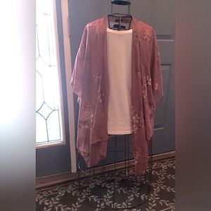 Flowing sheer cape adorned with Embroidered flowers.